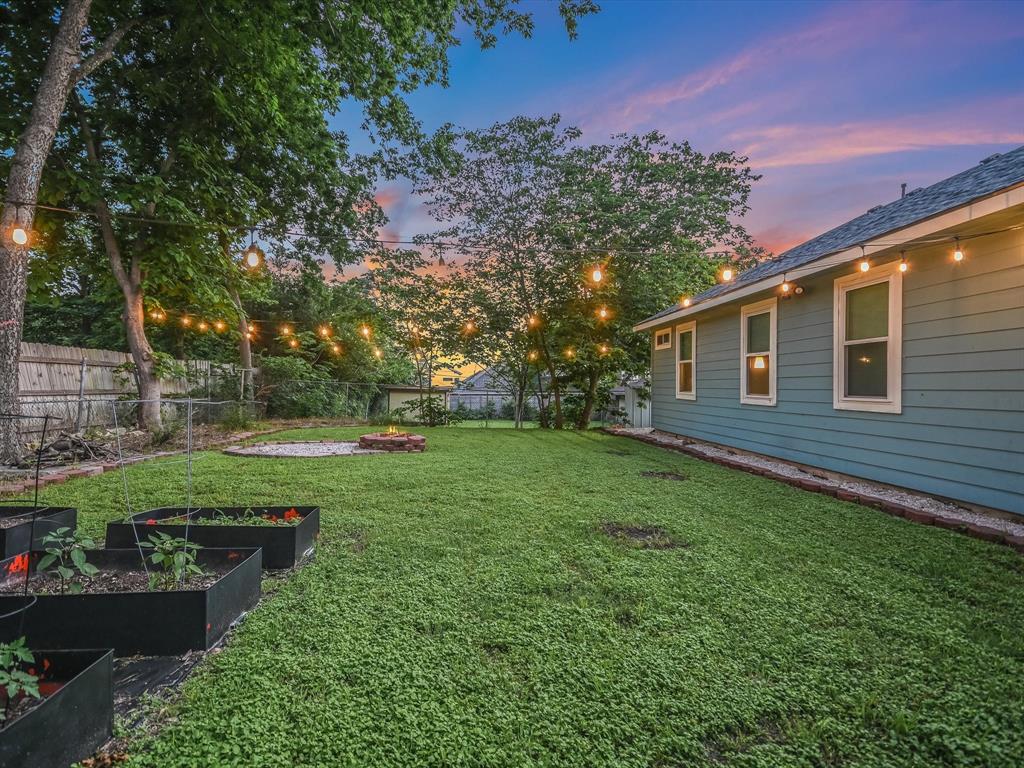 5405 Manor Road Austin, TX 78723 - Photo 27 of 30 Yard at dusk featuring a fenced backyard and a garden