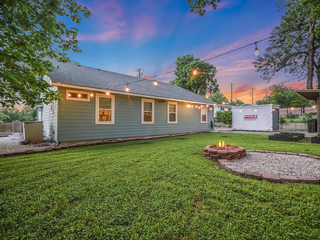 5405 Manor Road Austin, TX 78723 - Photo 29 of 30 Back of house with an outdoor fire pit, a yard, a shingled roof, and a patio