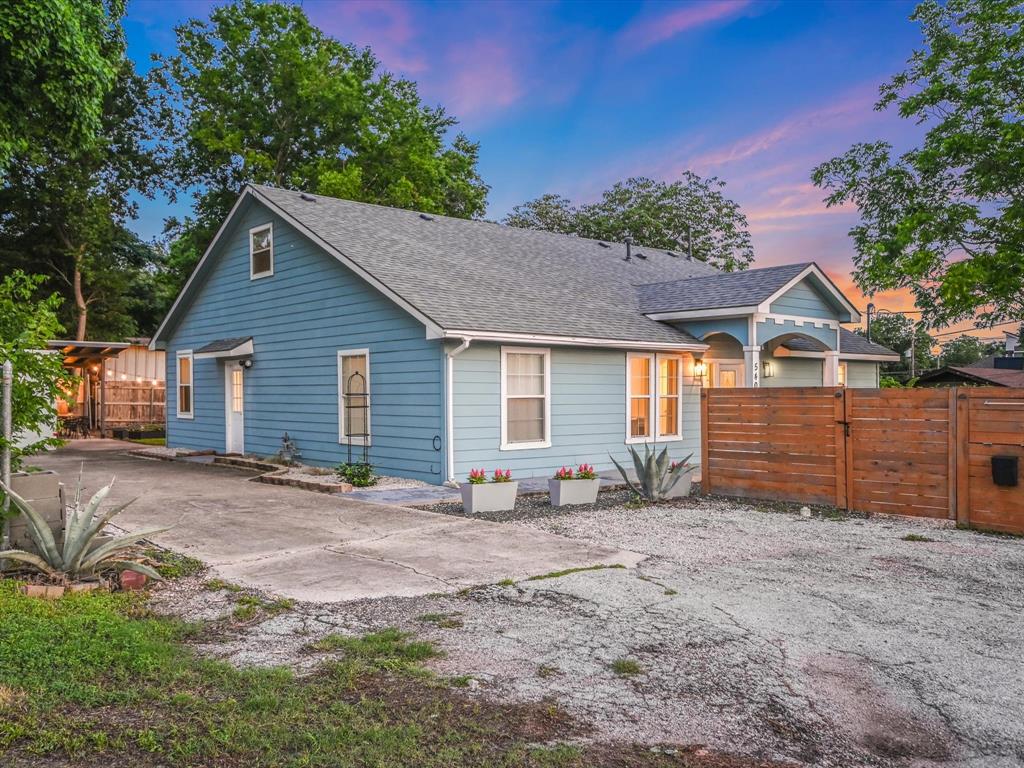 5405 Manor Road Austin, TX 78723 - Photo 30 of 30 Back of property at dusk featuring roof with shingles, a gate, and driveway
