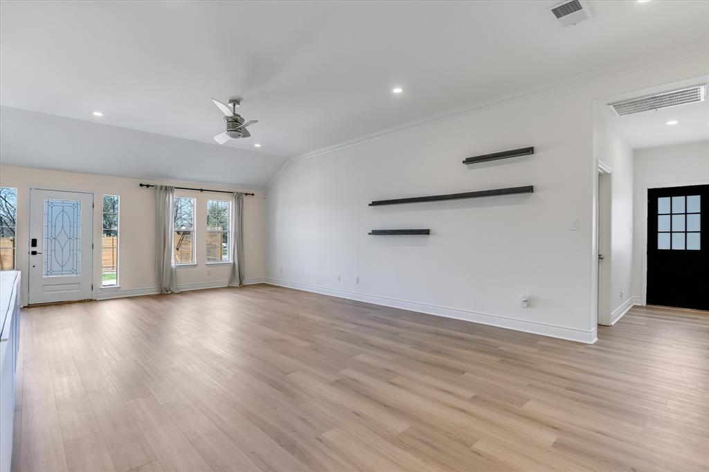 5405 Manor Road Austin, TX 78723 - Photo 6 of 30 Unfurnished living room with ceiling fan, light wood-type flooring, ornamental molding, recessed lighting, and vaulted ceiling