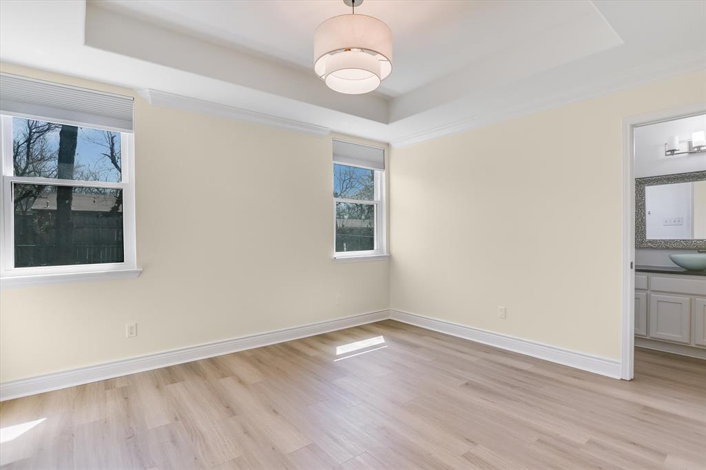 5405 Manor Road Austin, TX 78723 - Photo 8 of 30 Empty room featuring a raised ceiling and light wood-style flooring