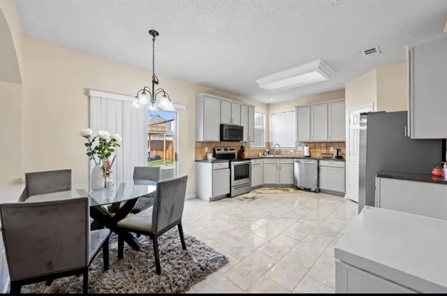 a kitchen with refrigerator a sink and chairs