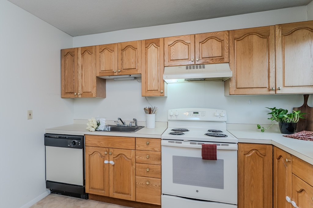 170 East Hadley Road, Unit 123 Amherst, MA 01002 - Photo 13 of 23 a kitchen with stainless steel appliances white cabinets and a stove top oven