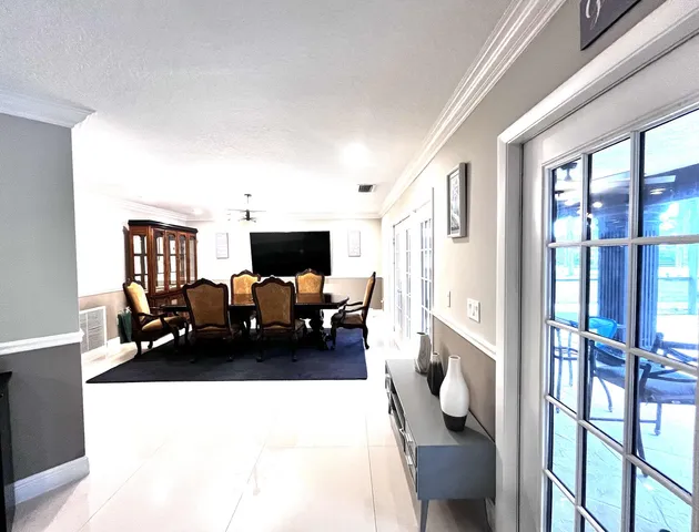 a living room with furniture a flat screen tv and kitchen view