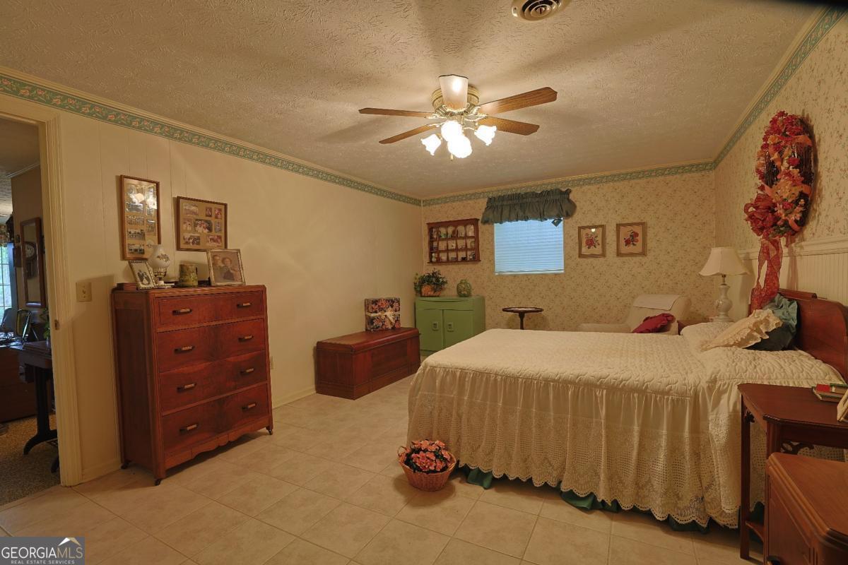 56 Claymont Road McIntyre, GA 31054 - Photo 25 of 75 a bedroom with a bed and a chandelier