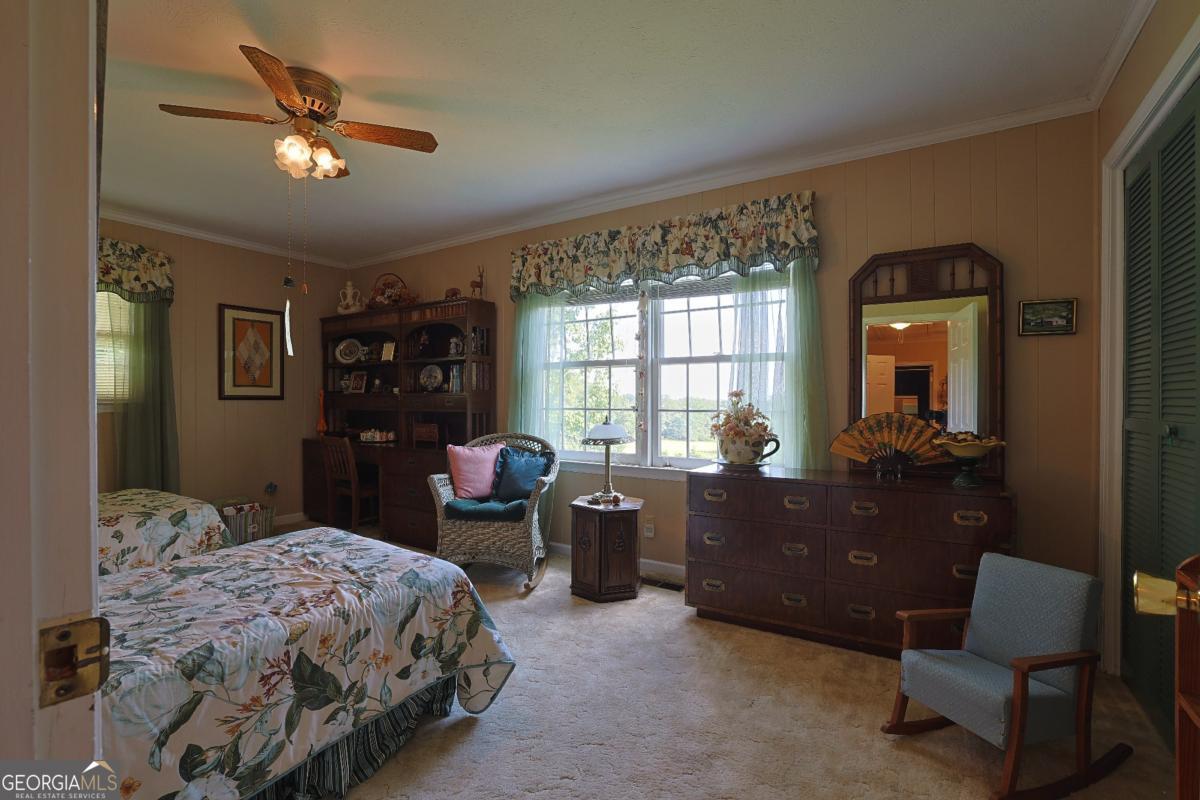 56 Claymont Road McIntyre, GA 31054 - Photo 48 of 75 a bedroom with a bed and a chandelier