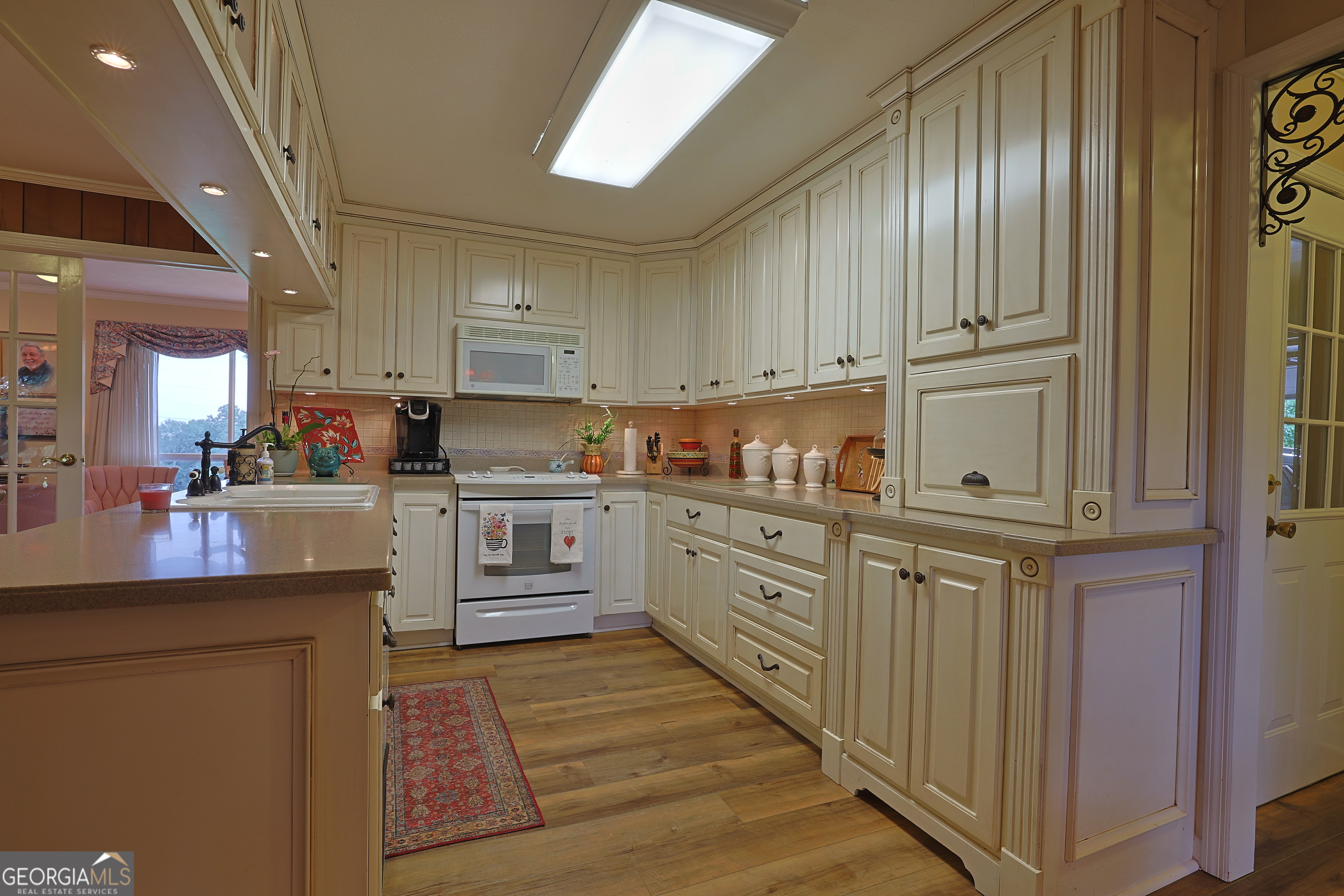 56 Claymont Road McIntyre, GA 31054 - Photo 71 of 75 a kitchen with cabinets oven and a dishwasher with wooden floor
