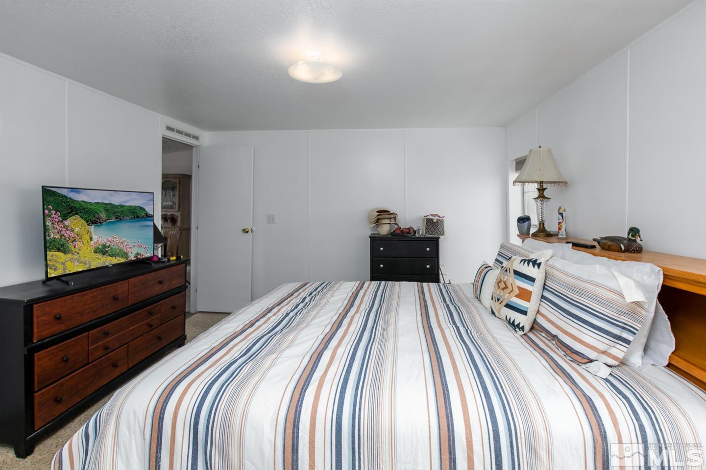 5215 Workman Road Fallon, NV 89406 - Photo 11 of 21 a bedroom with a bed and a flat screen tv