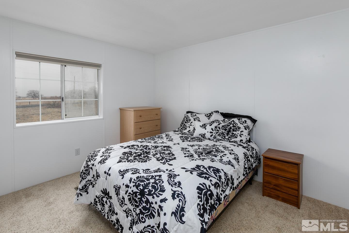 5215 Workman Road Fallon, NV 89406 - Photo 13 of 21 a bed sitting in a bedroom next to a window