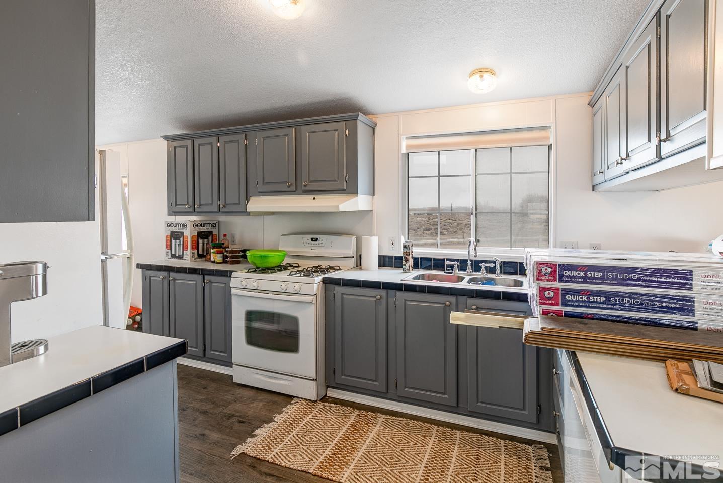5215 Workman Road Fallon, NV 89406 - Photo 6 of 21 a kitchen with a stove a sink and a microwave