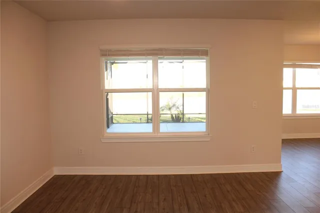 a view of a kitchen with kitchen island a sink wooden floor and a refrigerator