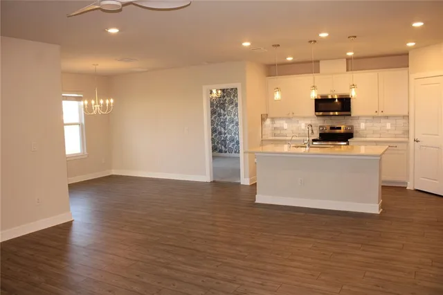 a view of kitchen refrigerator microwave and cabinets