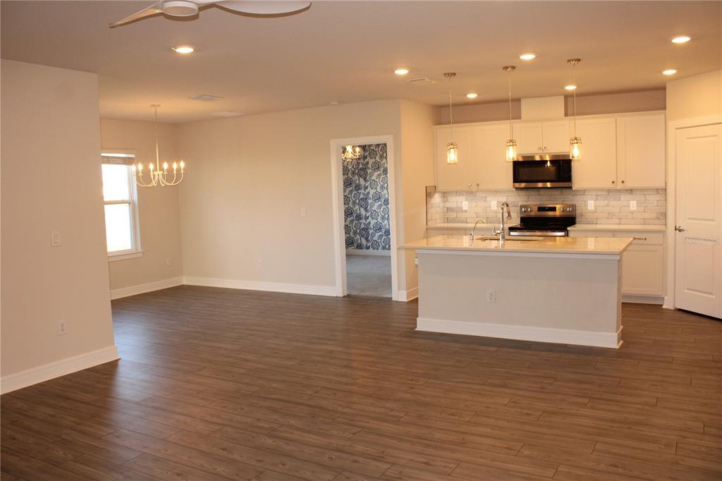 8232 Reefbay Cove Parrish, FL 34221 - Photo 16 of 64 a view of a kitchen with kitchen island a sink wooden floor and a refrigerator