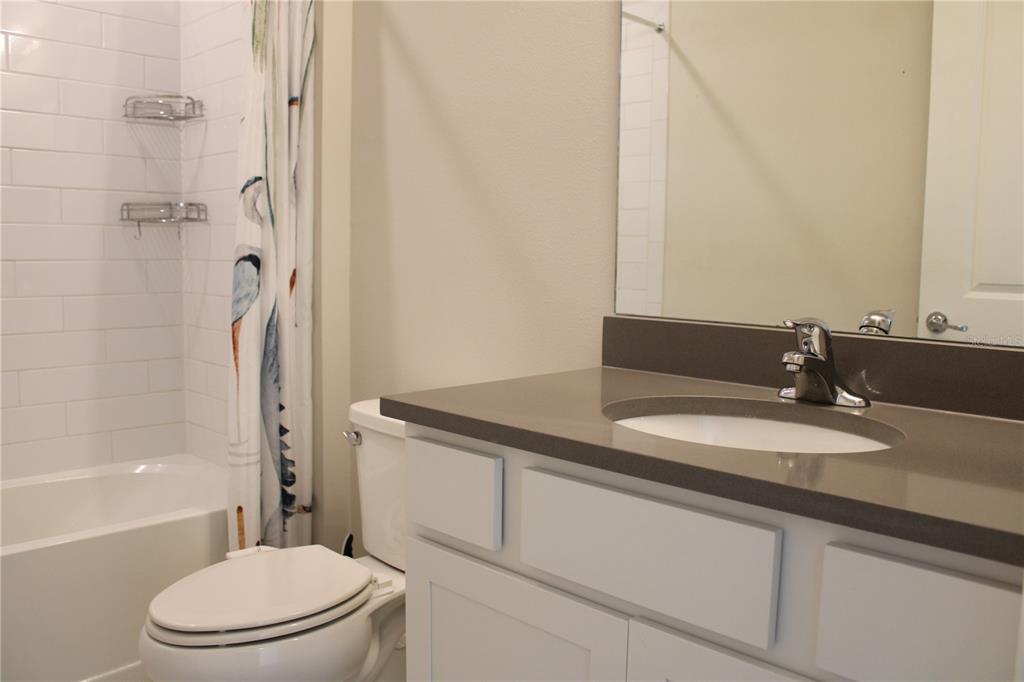 8232 Reefbay Cove Parrish, FL 34221 - Photo 30 of 64 a bathroom with a granite countertop sink toilet and shower