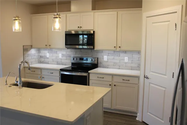 a kitchen with a sink a stove and cabinets