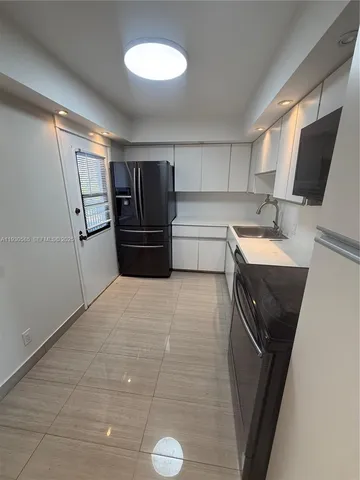 a room with a refrigerator and a sink