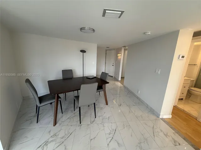 a view of a workspace with furniture and a refrigerator