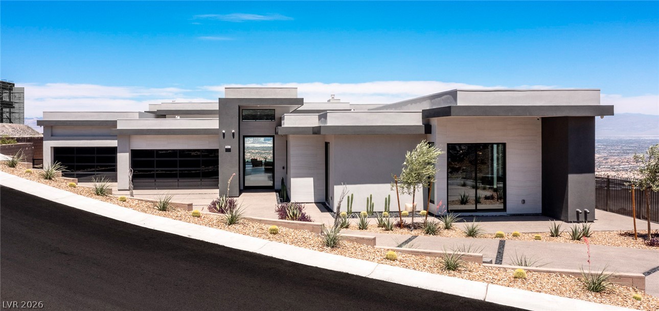 563 Grand Rim Drive Henderson, NV 89012 - Photo 68 of 70 Modern architecture on a sloping lot features a sleek entrance and desert-adapted landscaping.
