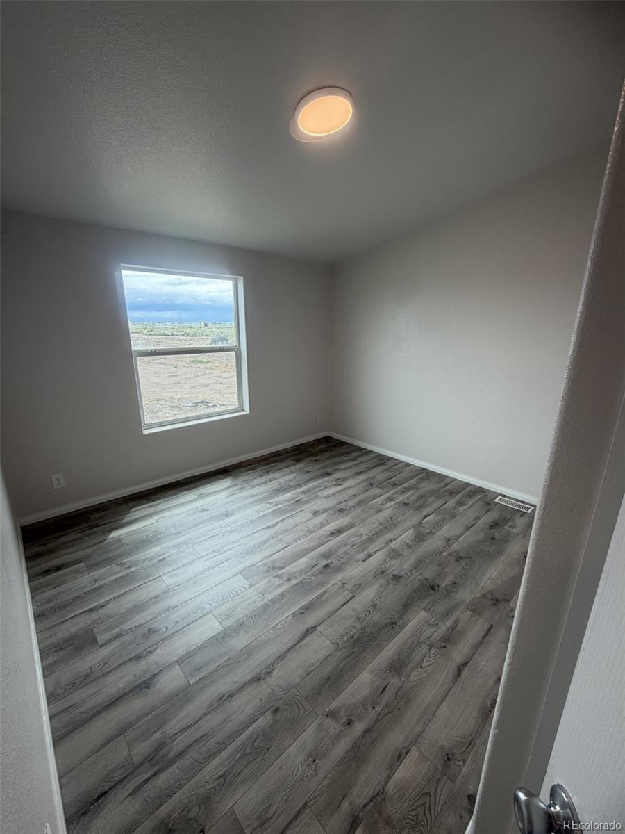 5511 Ridgetop Court Alamosa, CO 81101 - Photo 10 of 10 an empty room with wooden floor and windows
