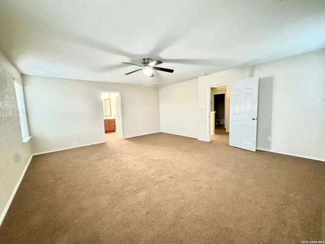 a view of an empty room with a ceiling fan