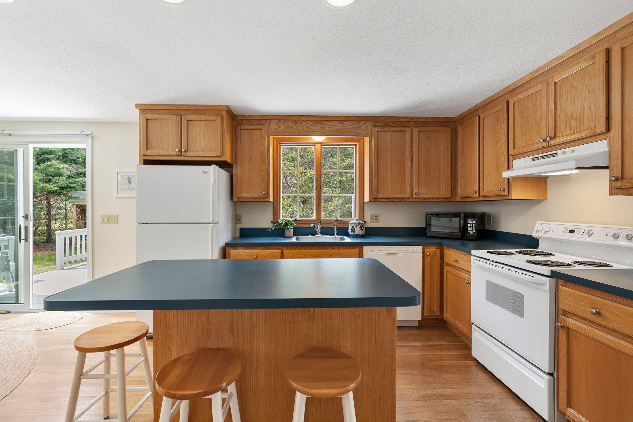 9 Raymond Way Eastham, MA 02642 - Photo 7 of 27 a kitchen with granite countertop a stove a sink dishwasher and a refrigerator with wooden floor