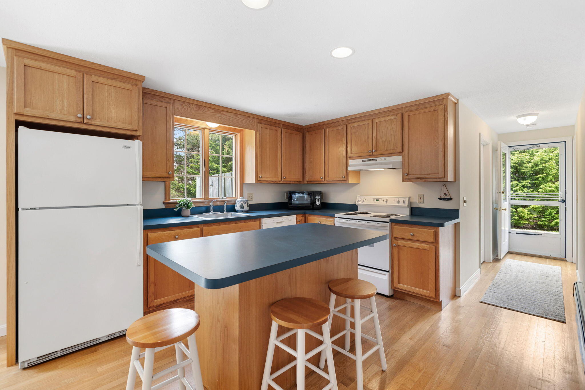 9 Raymond Way Eastham, MA 02642 - Photo 10 of 27 a kitchen with stainless steel appliances granite countertop a refrigerator a sink dishwasher a stove with wooden cabinets and wooden floor