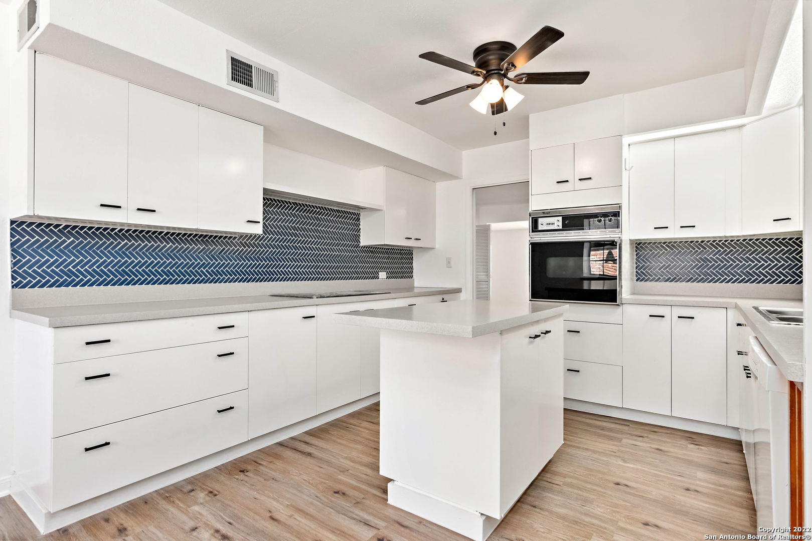 a kitchen with stainless steel appliances sink cabinets and stove top oven