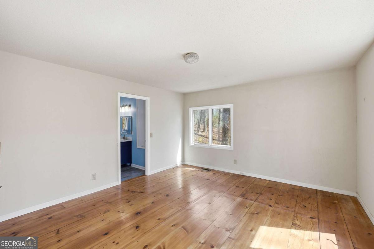 508 Providence Road Statham, GA 30666 - Photo 19 of 39 a view of an empty room with wooden floor and a window