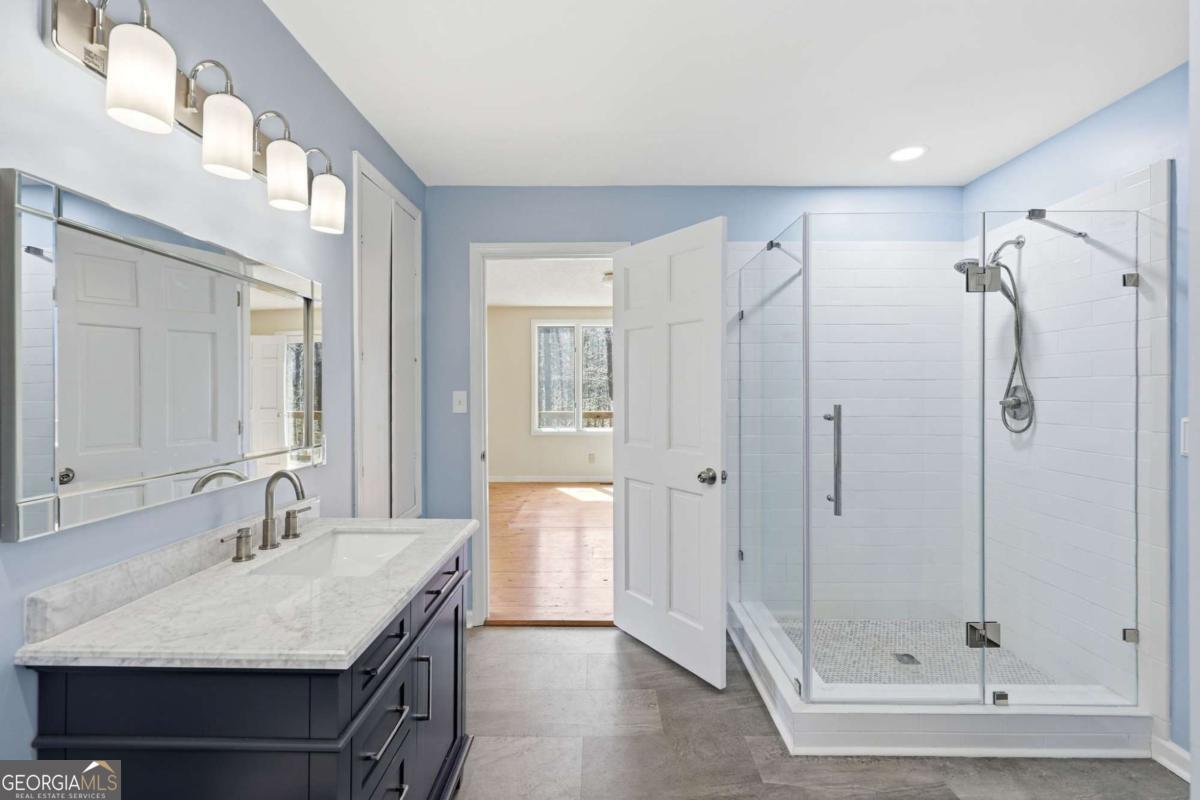 508 Providence Road Statham, GA 30666 - Photo 21 of 39 a bathroom with a granite countertop sink mirror and a shower