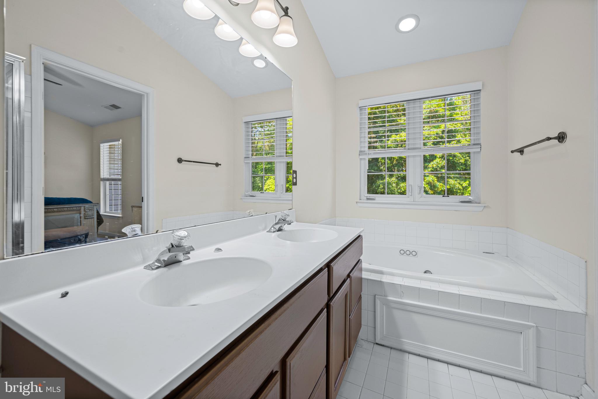 9837 Sherwood Farm Road Owings Mills, MD 21117 - Photo 23 of 35 a bathroom with a sink vanity tub and a mirror