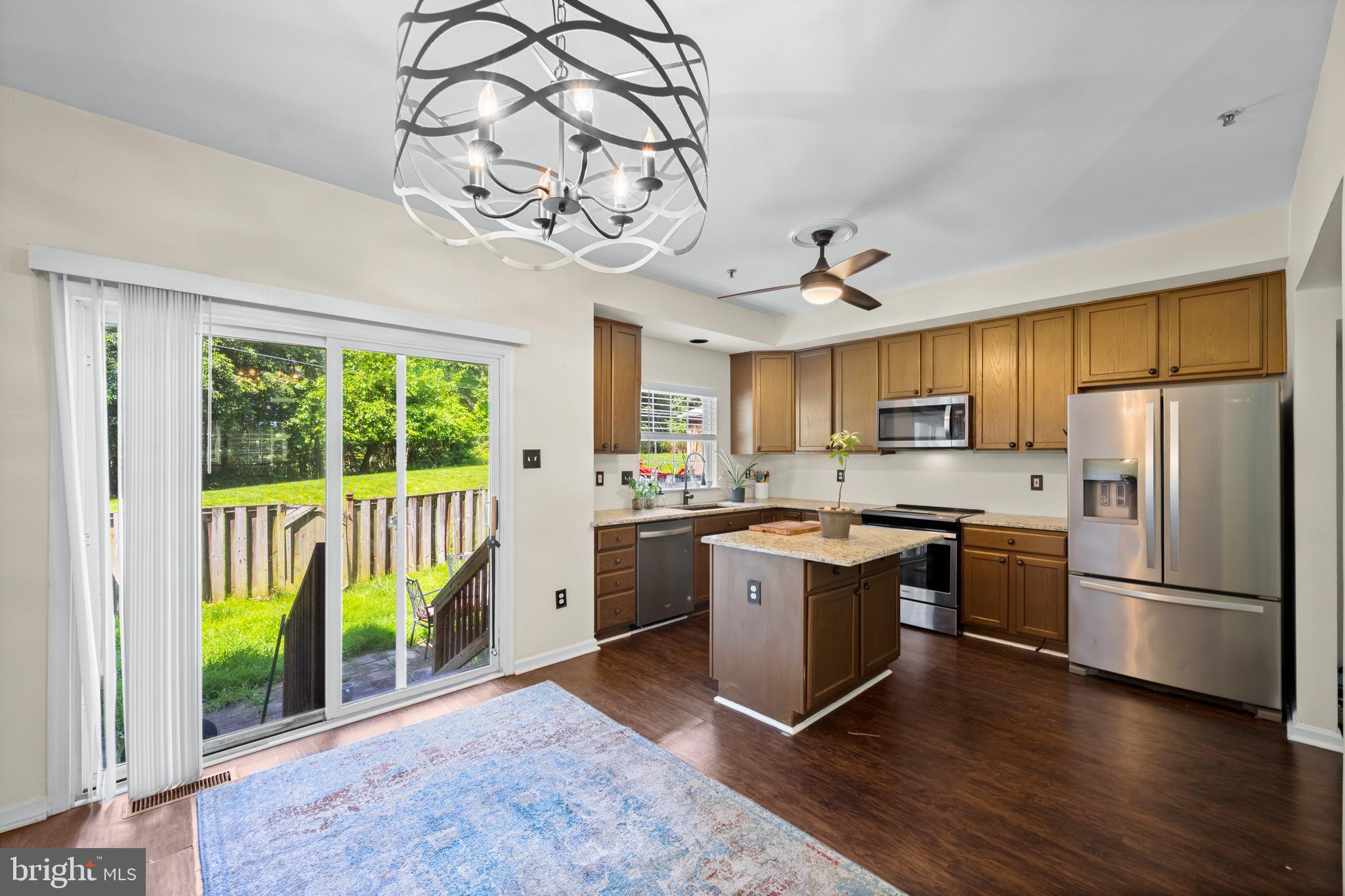 9837 Sherwood Farm Road Owings Mills, MD 21117 - Photo 8 of 35 a kitchen with stainless steel appliances granite countertop a stove top oven a sink dishwasher a refrigerator and a fireplace with wooden floor