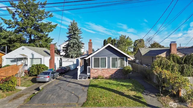 a view of a house with a big yard plants and large tree