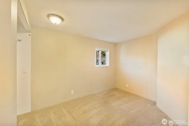 a view of a room with a white wall and a window