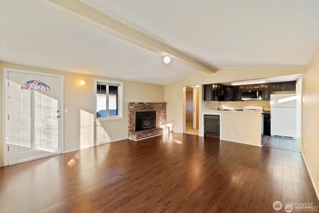 a view of a kitchen with a sink stove cabinets and empty room