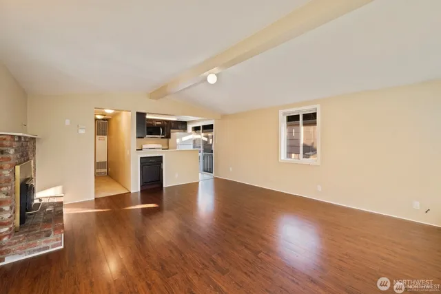 a view of a kitchen with a sink stove cabinets and empty room