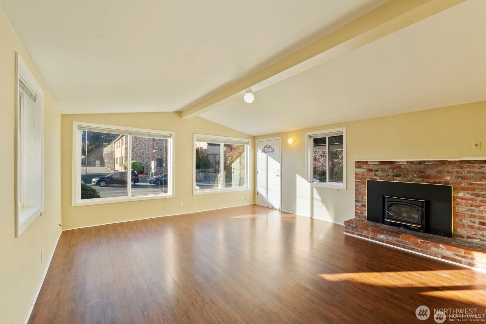 120 North 80th Street Seattle, WA 98103 - Photo 6 of 39 a view of an empty room with wooden floor and a fireplace