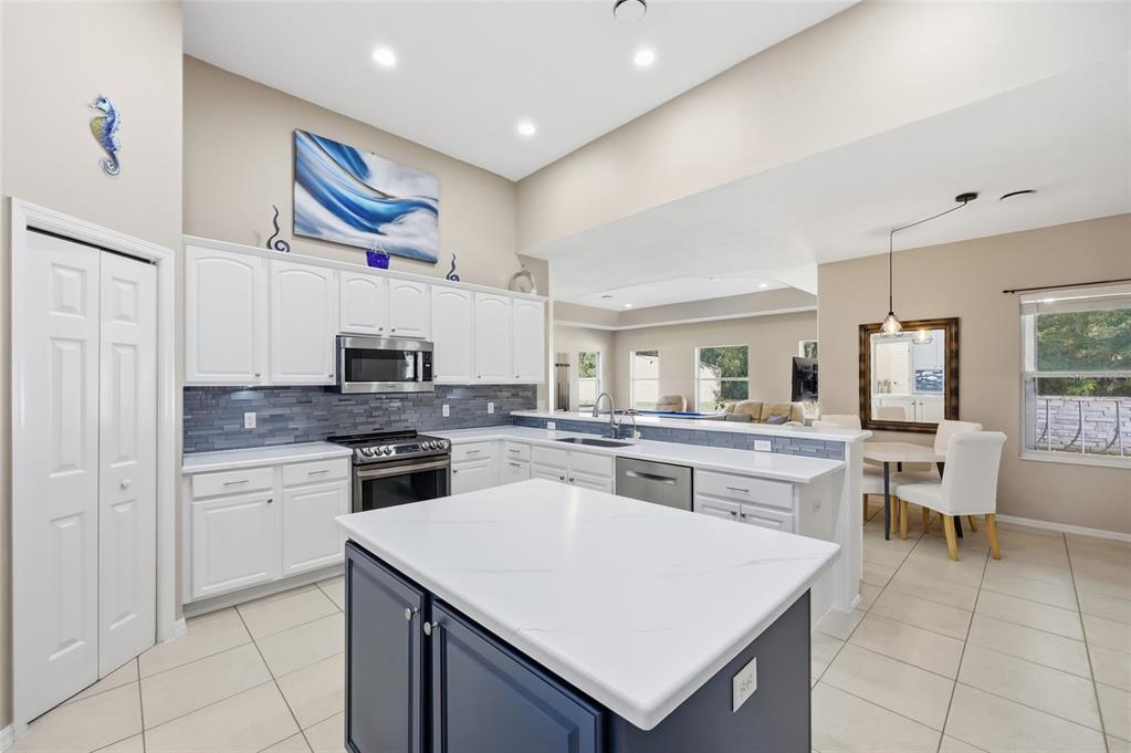 4060 South Kenvera Loop Inverness, FL 34450 - Photo 23 of 50 a kitchen with a stove a sink a kitchen island with chairs and cabinets