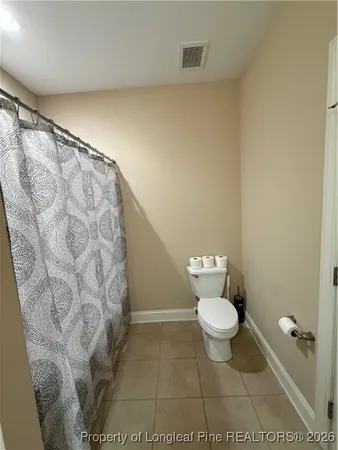 a bathroom with a toilet and a shower curtain