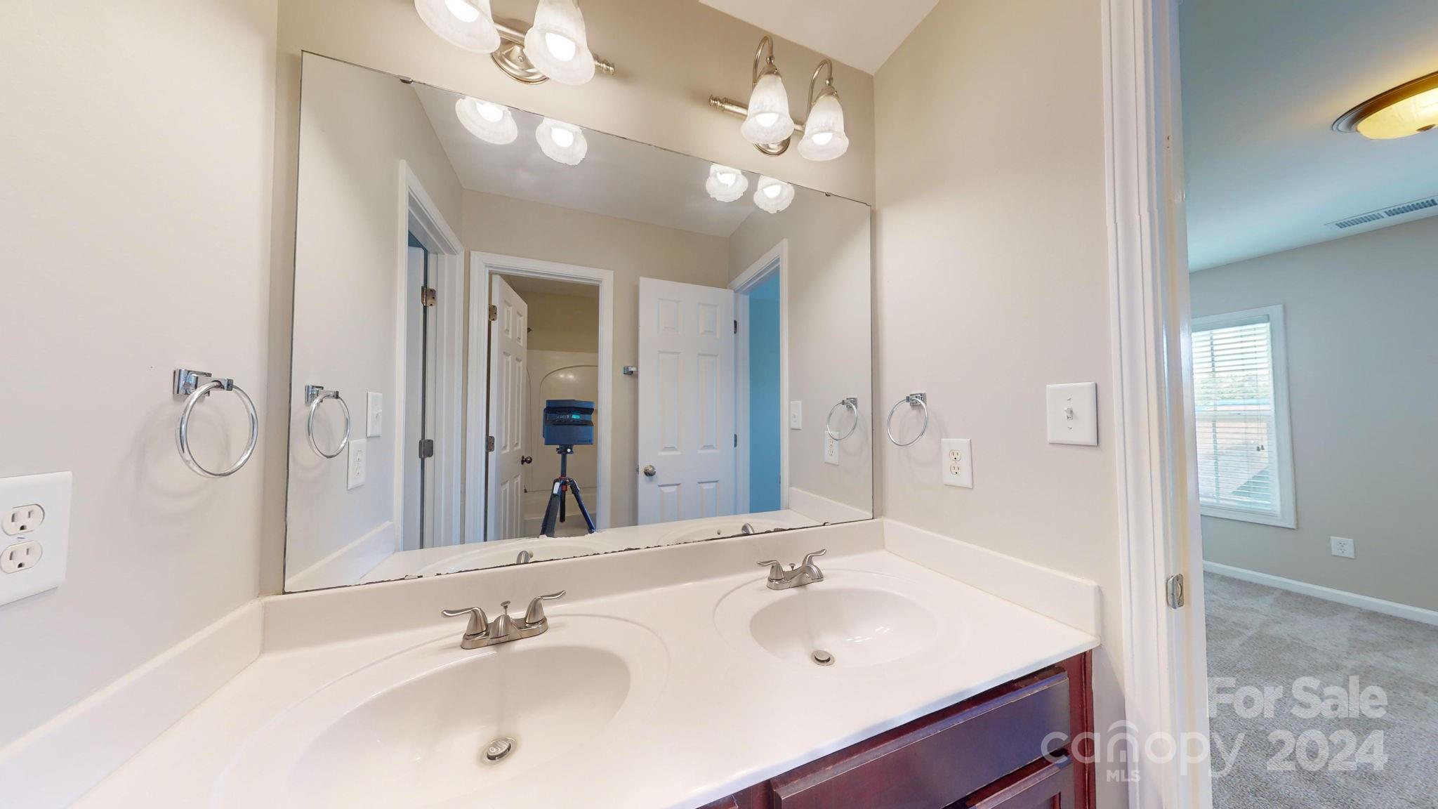8386 Burgundy Ridge Drive Harrisburg, NC 28075 - Photo 16 of 44 a bathroom with a sink double vanity and a mirror