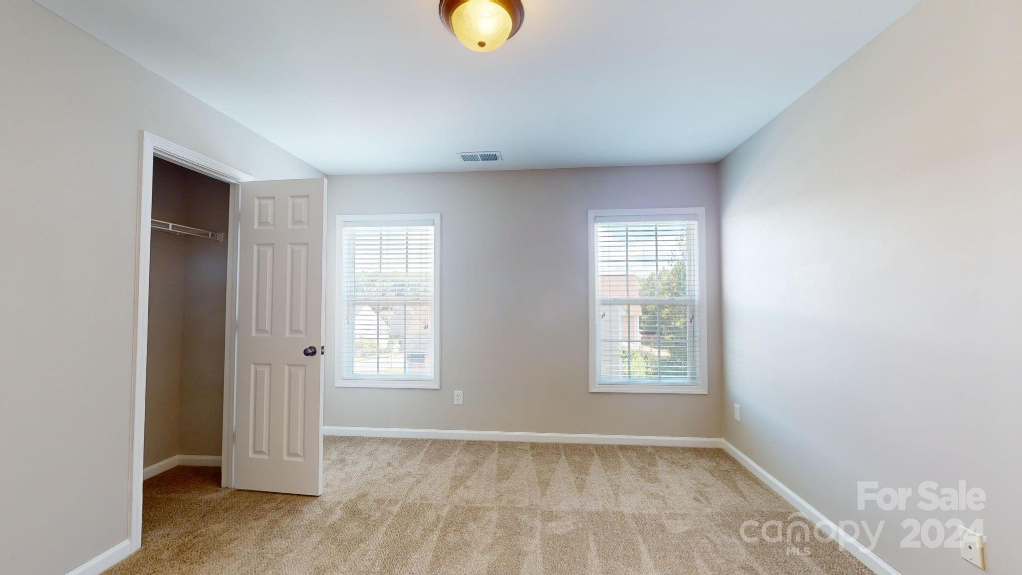 8386 Burgundy Ridge Drive Harrisburg, NC 28075 - Photo 18 of 44 an empty room with windows and closet