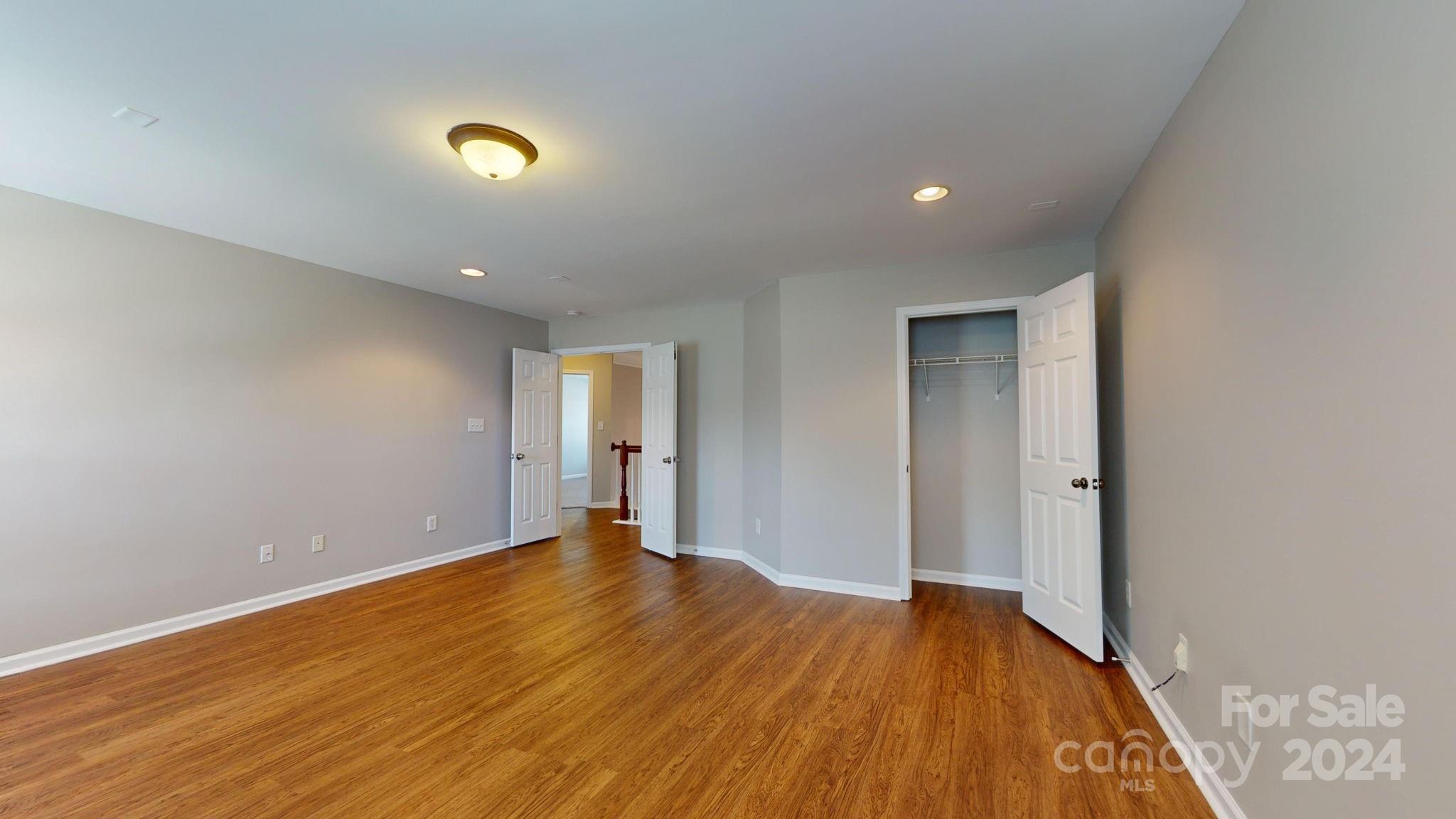 8386 Burgundy Ridge Drive Harrisburg, NC 28075 - Photo 21 of 44 a view of an empty room with wooden floor and closet