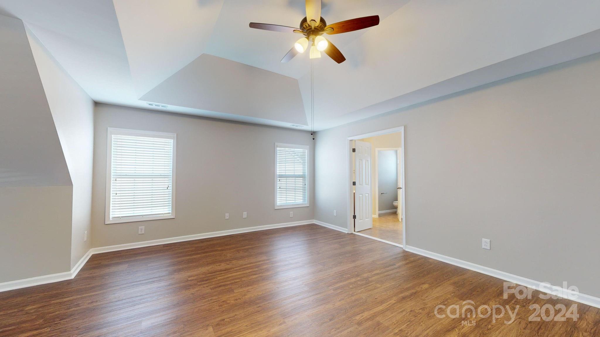 8386 Burgundy Ridge Drive Harrisburg, NC 28075 - Photo 23 of 44 a view of empty room with wooden floor and fan