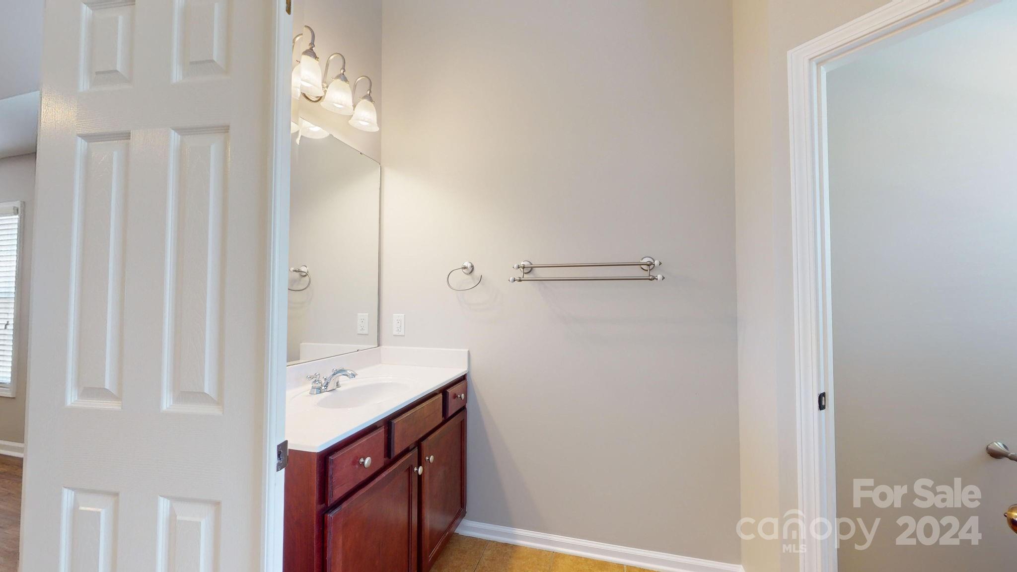 8386 Burgundy Ridge Drive Harrisburg, NC 28075 - Photo 26 of 44 a bathroom with a sink vanity and a mirror