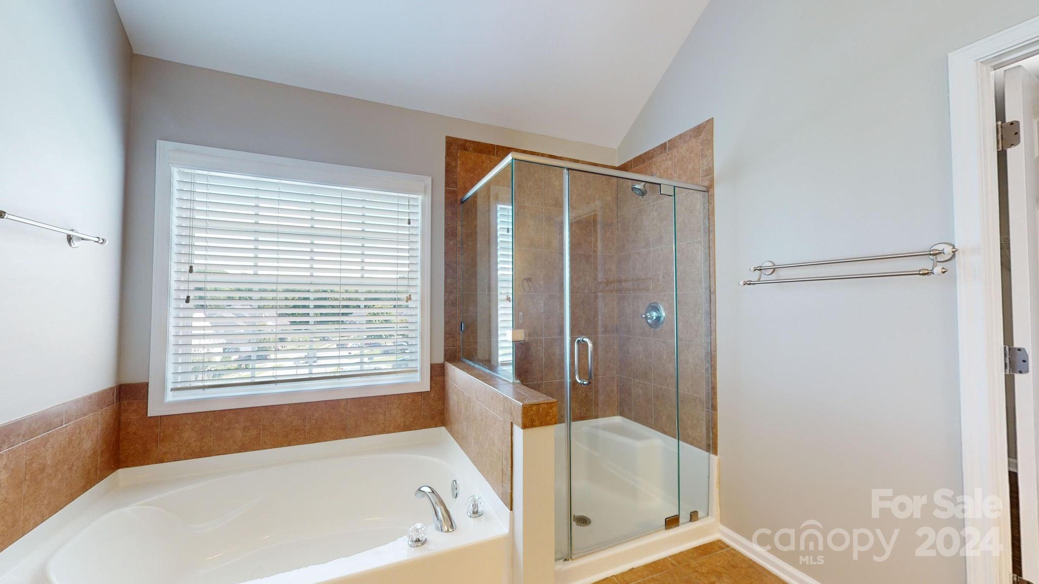 8386 Burgundy Ridge Drive Harrisburg, NC 28075 - Photo 27 of 44 a bathroom with a bathtub and a shower