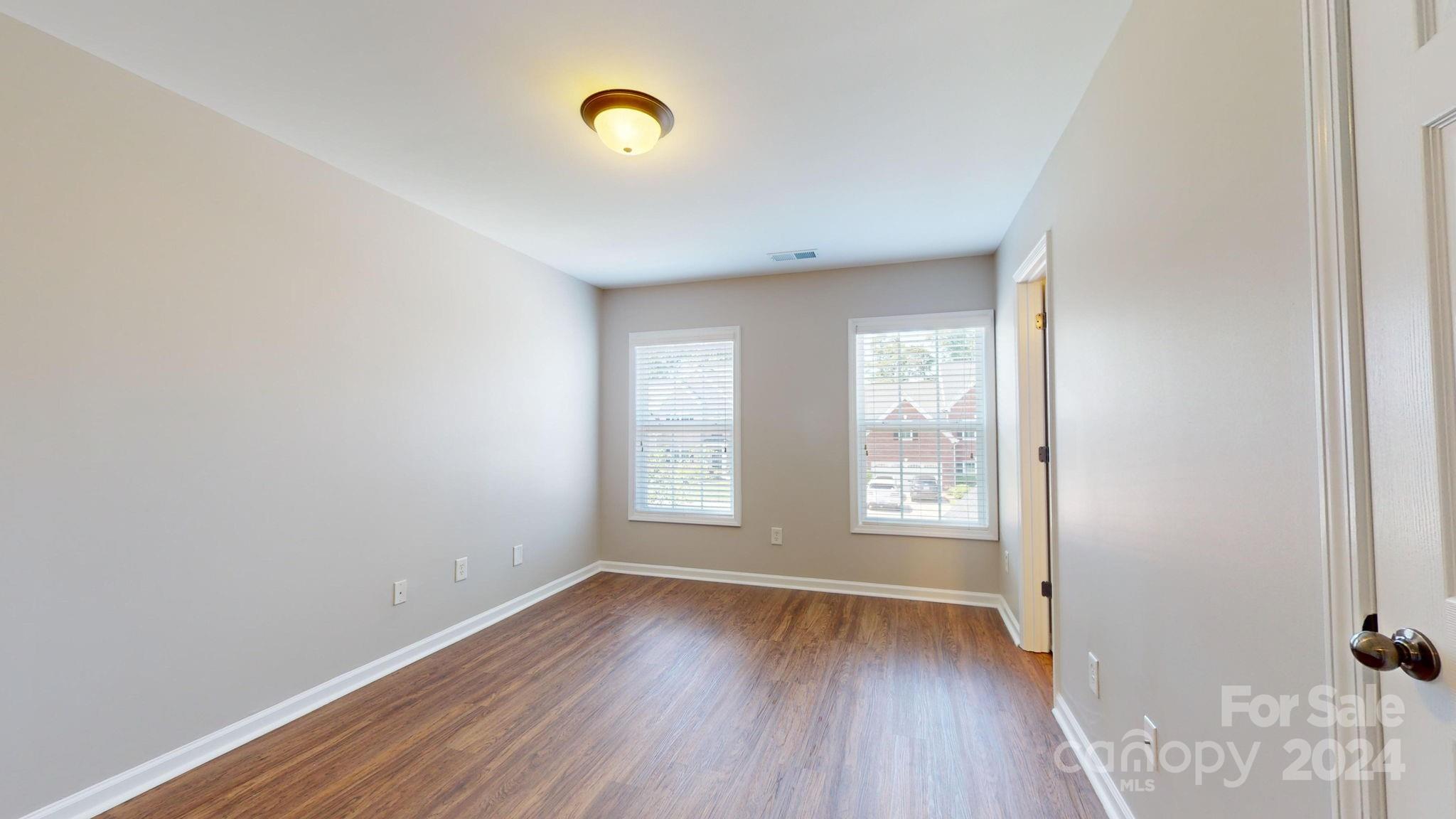 8386 Burgundy Ridge Drive Harrisburg, NC 28075 - Photo 32 of 44 a view of an empty room with wooden floor and a window