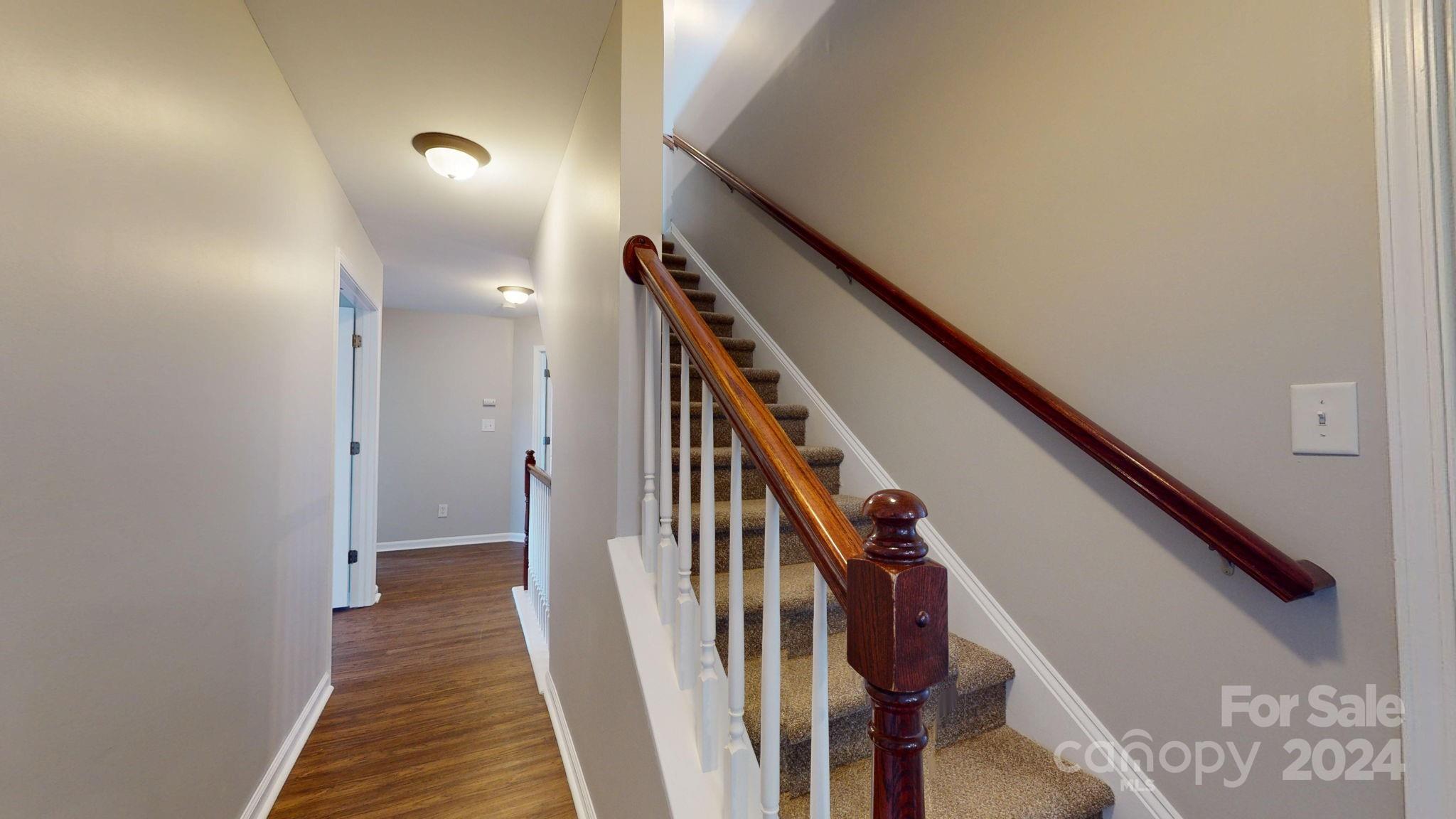 8386 Burgundy Ridge Drive Harrisburg, NC 28075 - Photo 35 of 44 a view of a hallway with wooden floor and stairs