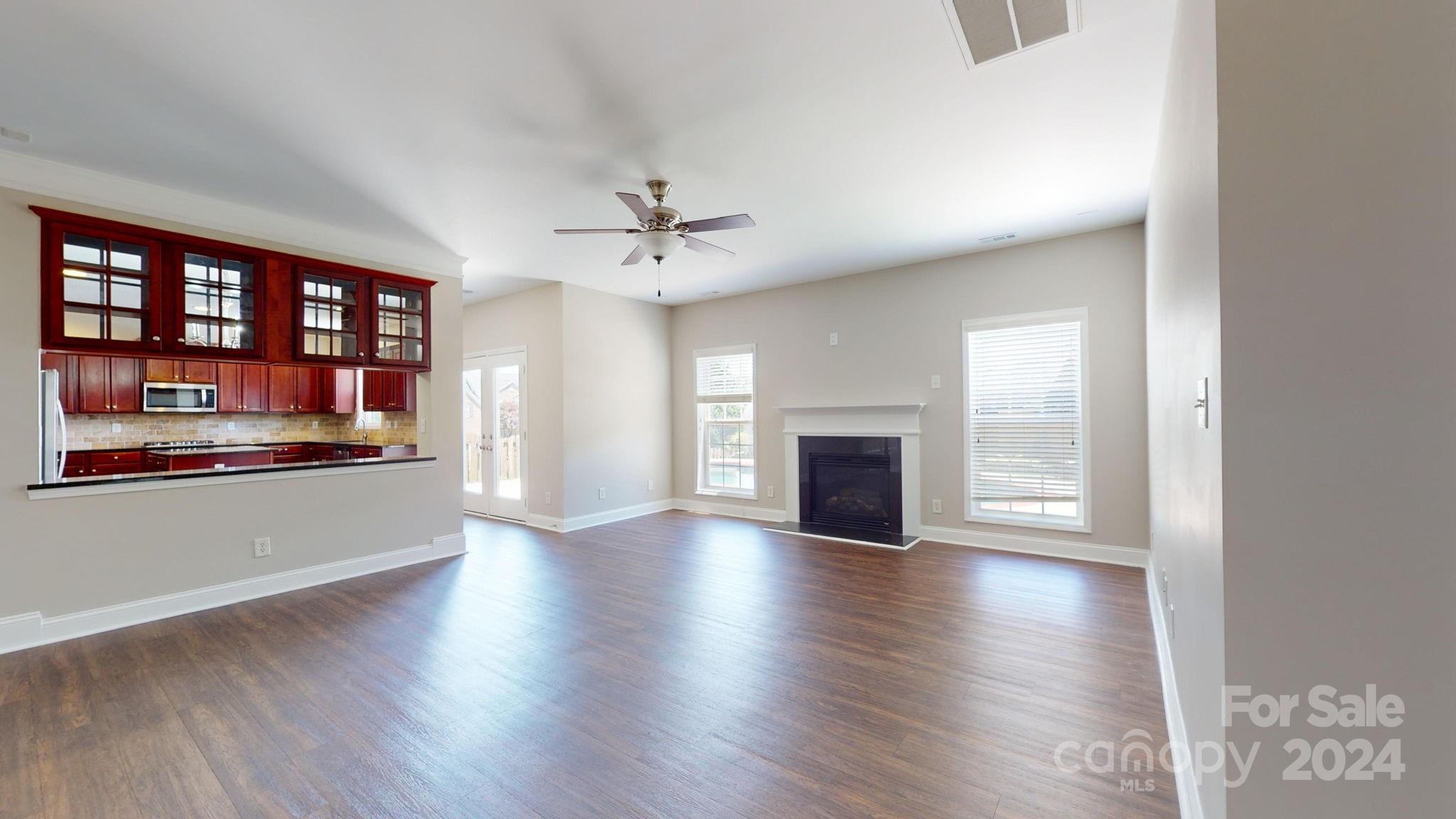 8386 Burgundy Ridge Drive Harrisburg, NC 28075 - Photo 6 of 44 an empty room with wooden floor and fireplace