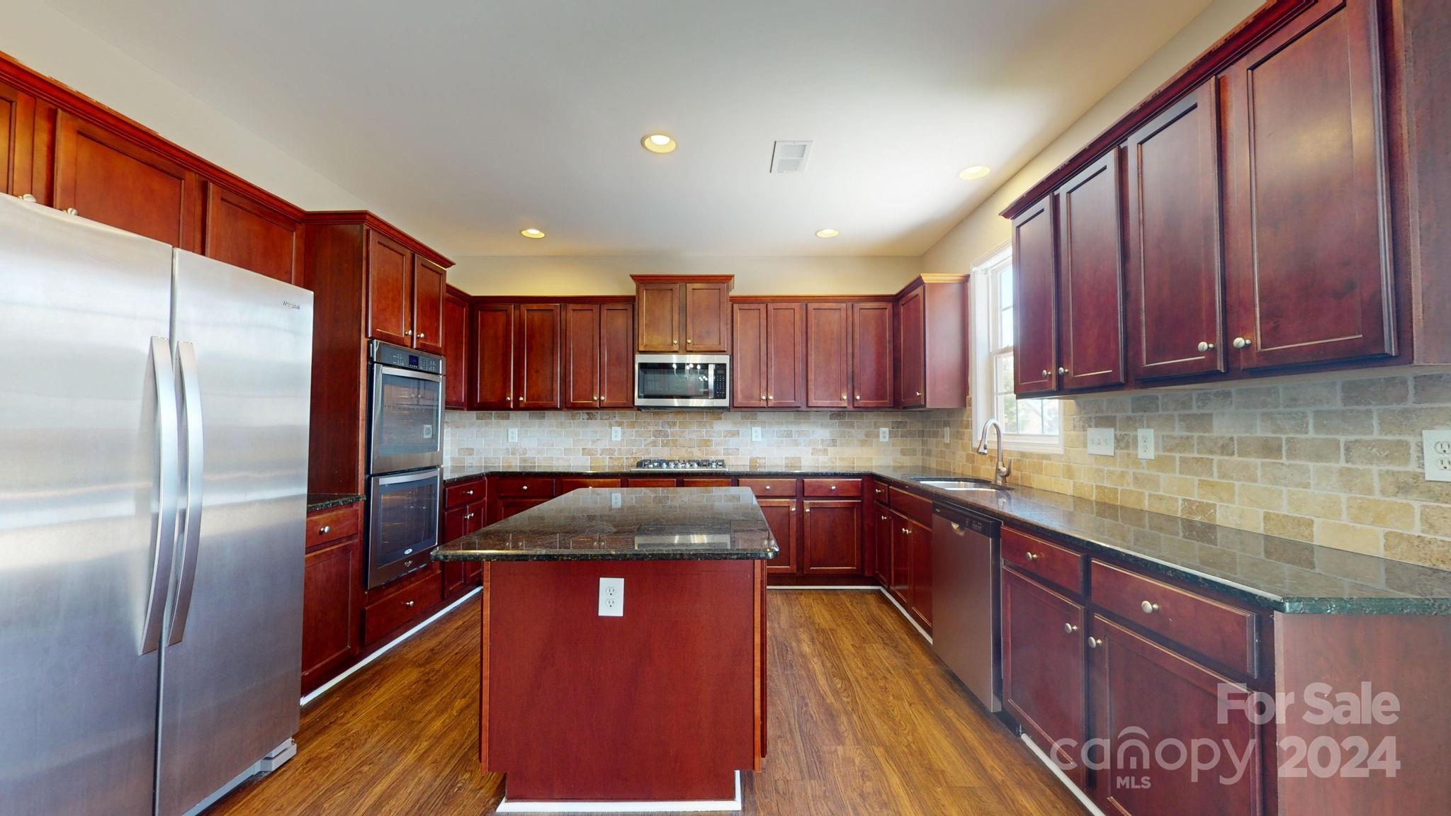 8386 Burgundy Ridge Drive Harrisburg, NC 28075 - Photo 7 of 44 a kitchen with stainless steel appliances granite countertop a refrigerator a sink and a stove