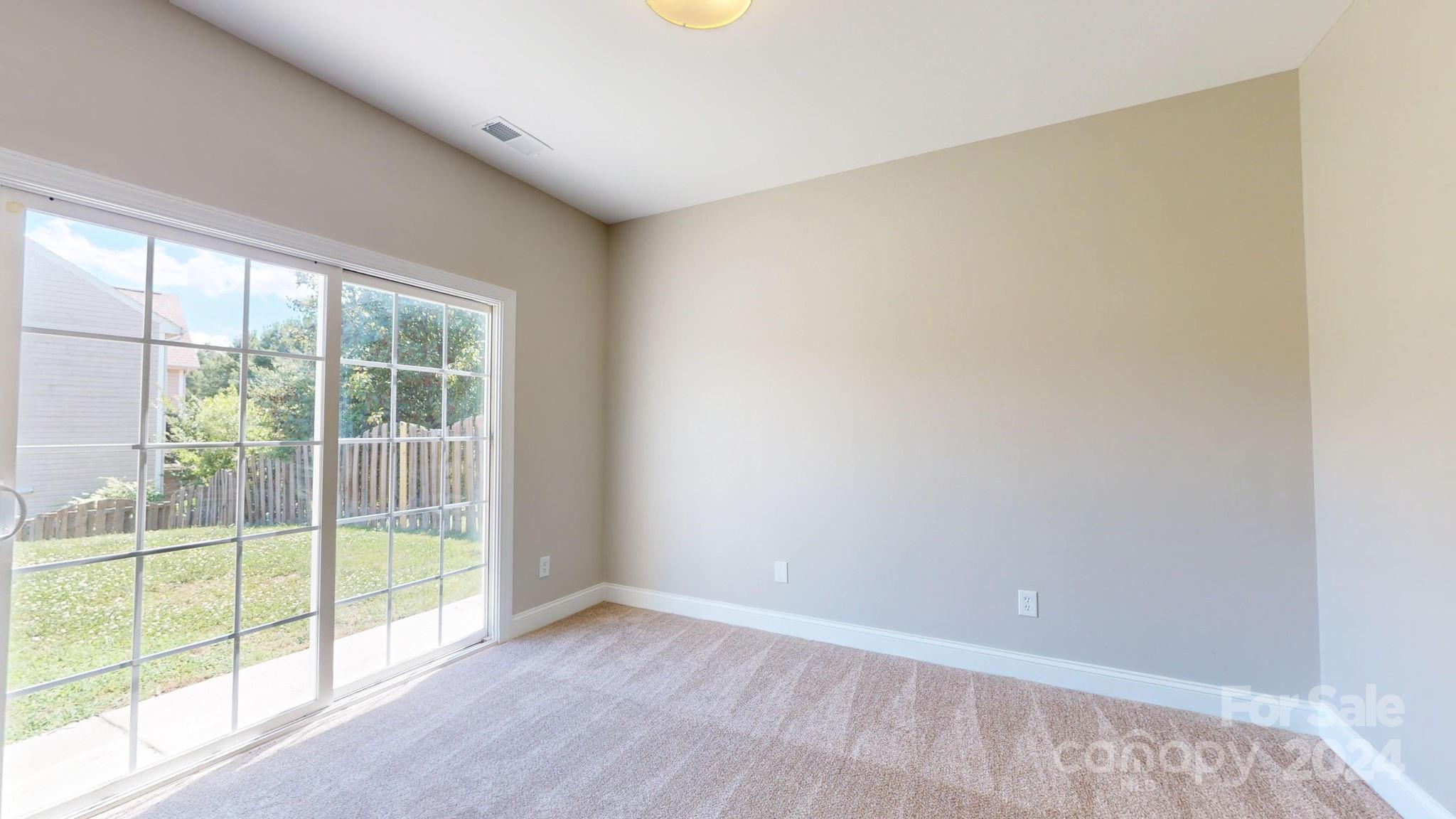 8386 Burgundy Ridge Drive Harrisburg, NC 28075 - Photo 10 of 44 an empty room with wooden floor and windows
