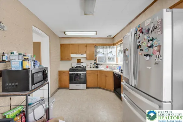a kitchen with stainless steel appliances a refrigerator and a stove top oven